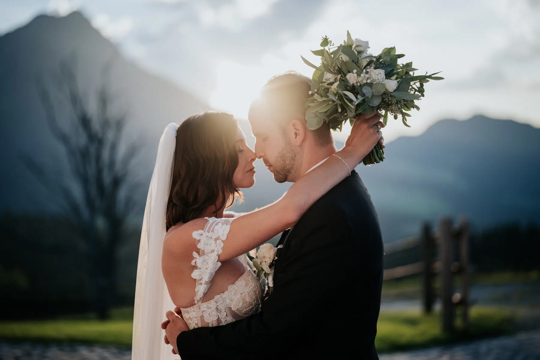 Romantischer Hochzeitskuss im Winterstellgut bei Sonnenuntergang Schwarz Weiß Aufnahme