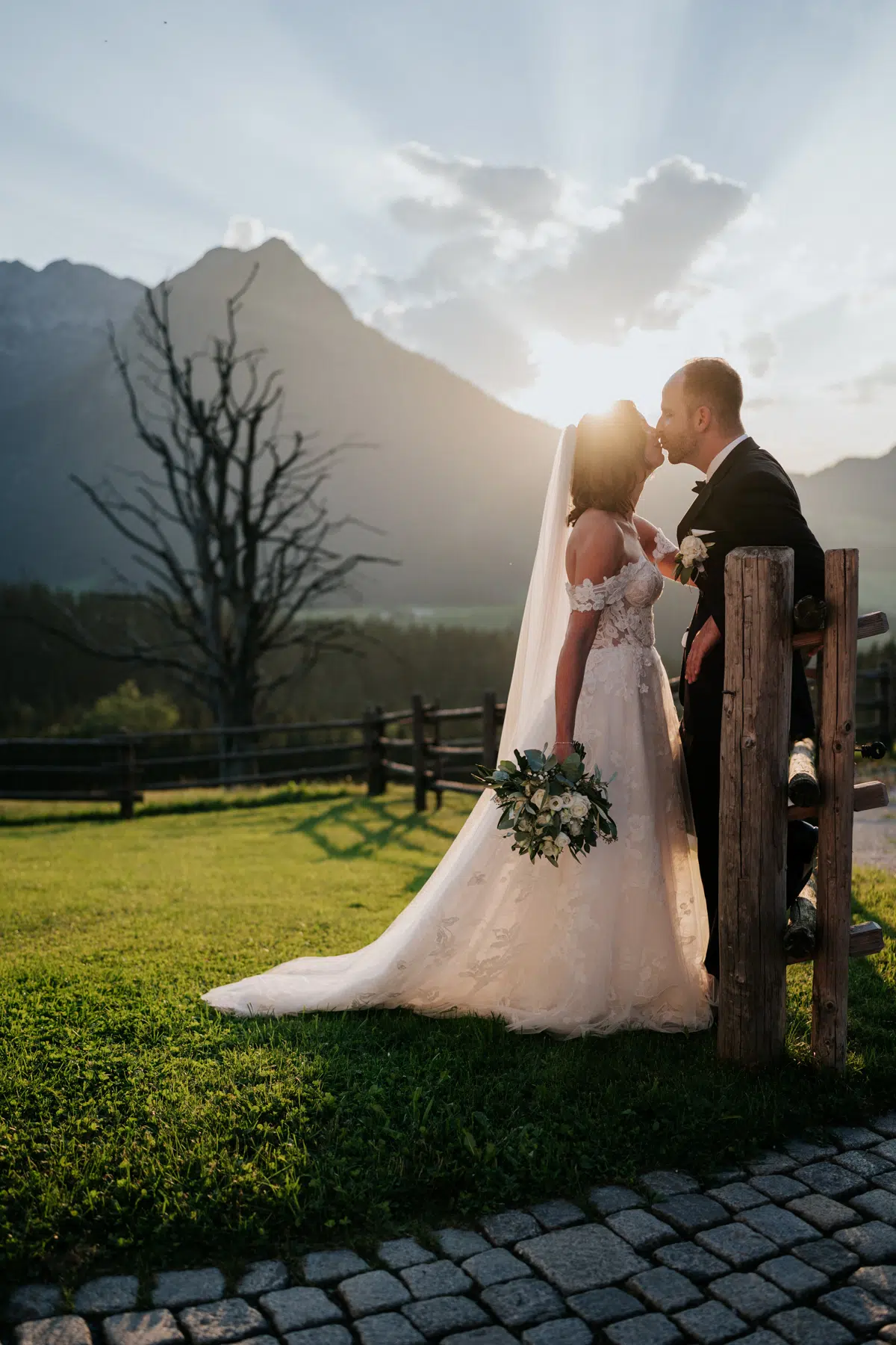 Emotionale Hochzeitsaufnahme im Winterstellgut Brautpaar im warmen Abendlicht